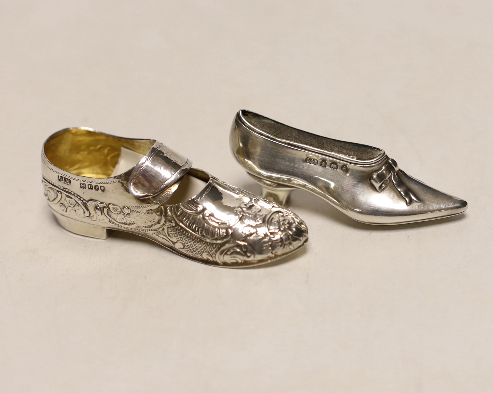 An Edwardian novelty silver pin cushion, modelled as a shoe, Levi & Salaman, Birmingham, 1904, 68mm, together with a silver model of a shoe, import marks for Elly Isacc Miller, London, 1897.